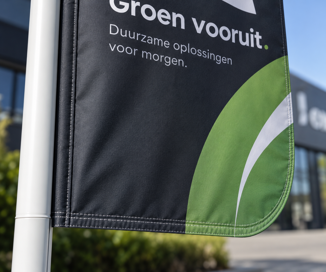 Close-up van professioneel stikwerk en een afgeronde hoek rechtsonder aan een baniervlag